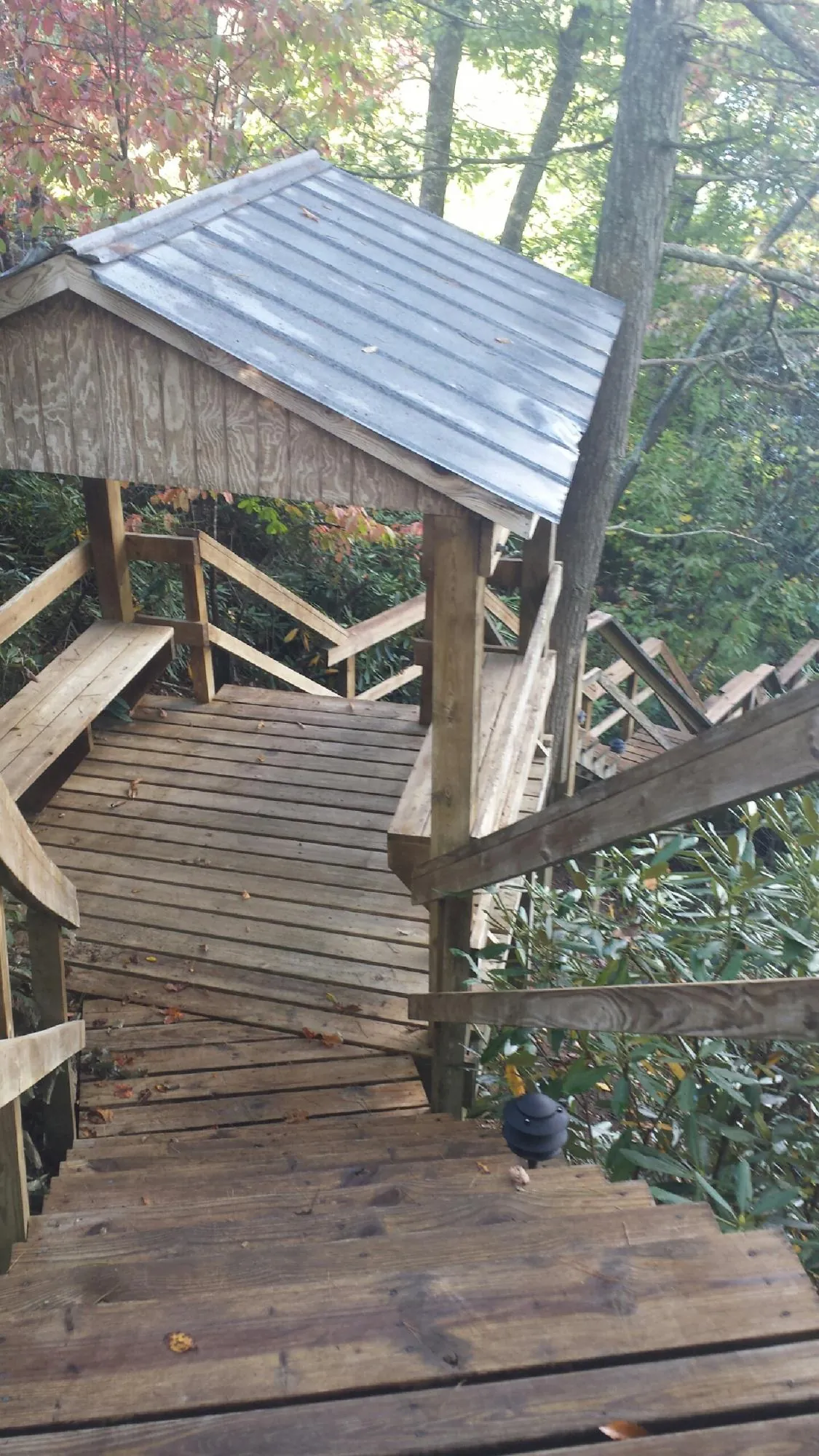 Metal roofed shelter over wooden steps on a wooded walkway — Skylight Repair & Installation work by our crew in Newport News