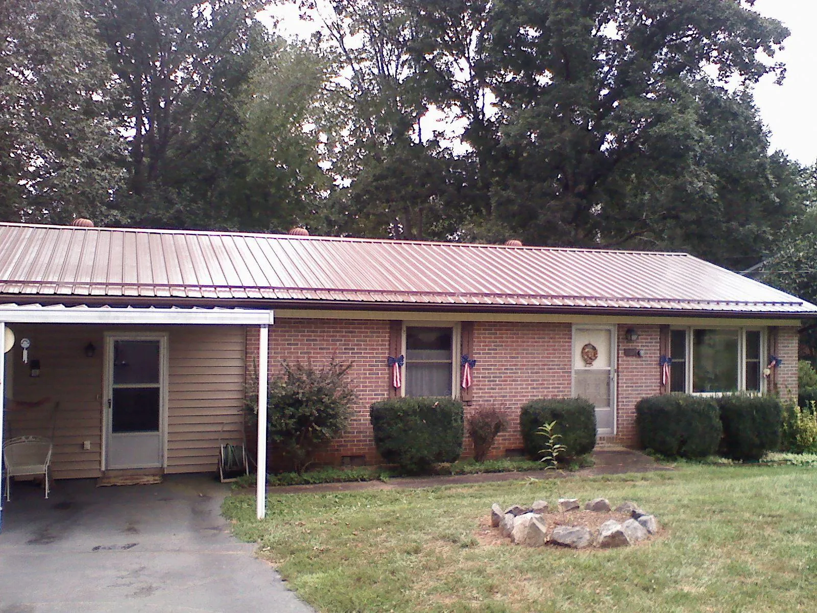 Bronze metal roof and carport on a brick ranch home — Roof Repair work by our crew in Newport News